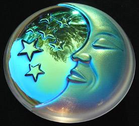 Moon and Stars Crystal AB Paperweight. Note the Light Accenting the High Points Such as the Eyelid, Cheek, and Lips and Glowing Through the Chin. Trees are reflected in the Shiny Starry Side.